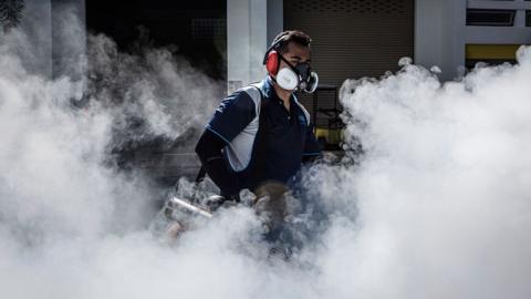 A pest control worker fumigates the grounds of a apartment block in Aljunied on September 3, 2016 in Singapore.