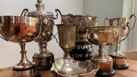 A collection of old trophies on a table.