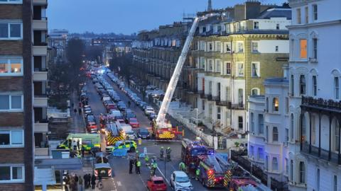Emergency services are dealing with the fire in a room on the fourth room of a hotel in a terraced street