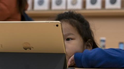 A girl on an iPad in a Apple store in China
