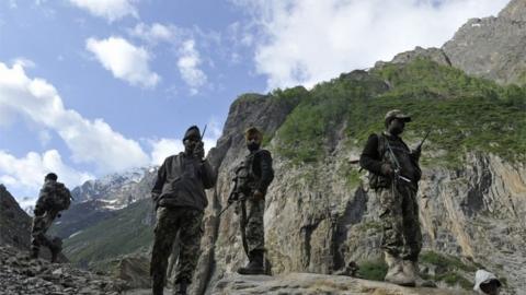 Indian Border Security Force (BSF) soldiers stand guard as Hindu pilgrims begin their annual journey from Baltal Base Camp to the holy Amarnath Cave Shrine, in Baltal