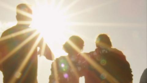 Silhouettes of people walking in the sun