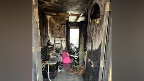 The hall of a home which is badly damaged by a fire