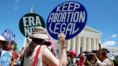 Abortion rights activists holding signs protest outside the US Supreme Court Building in Washington DC.