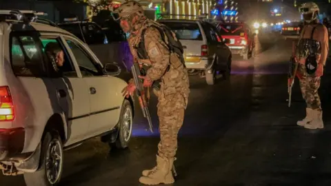 Taliban security check a vehicle at a checkpoint in Kabul,