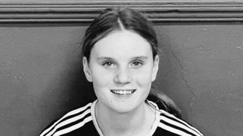 Black and white picture of a teenage girl with long hair in a pony tail