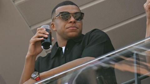 Kylian Mbappe stands on the balcony in the pit lane of the Circuit de Monaco for an F1 race