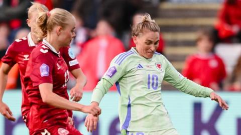 Wales' Jess Fishlock (R) runs with the ball