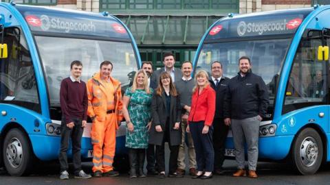 Officials from Devon County Council, Barnstaple Town Council and Stagecoach South West stand in front of two of the new buses.