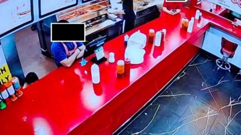 A CCTV image of a fast food takeaway counter