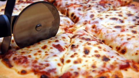 A pizza being sliced