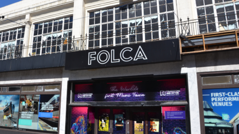 A black building called Folca with billboards up.