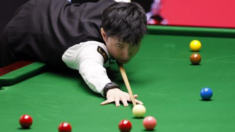 Zhao Xintong plays a shot