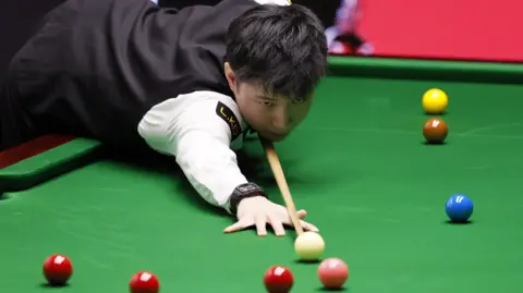 Zhao Xintong plays a shot