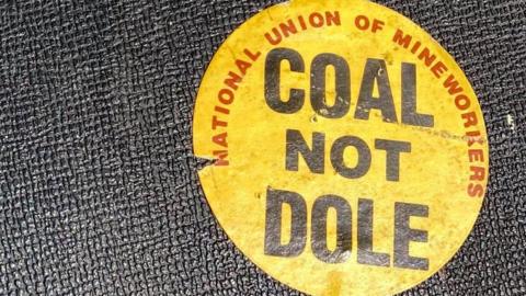 A yellow National Union of of Mineworkers 'COAL NOT DOLE' sticker