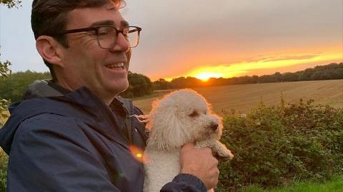 Andy Burnham holding Axel the white Bichon-Poo