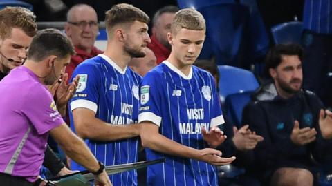Axel Donczew (R) prepares to come on as a substitute for Cardiff against Newport