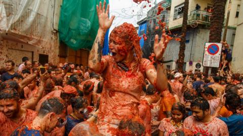 Revellers enjoy the atmosphere in tomato pulp while participating the annual Tomatina festival on August 30, 2017 in Bunol, Spain.