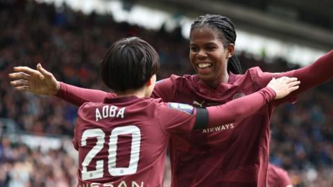 Aoba Fujino and Khadija Shaw celebrate a goal in the League up final