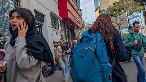 People head for cover in Tehran. 