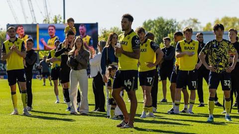 Oxford United players applaud fans after the final home match of the season