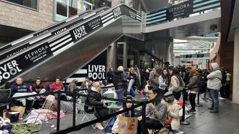 People camp out in the open in Liverpool ONE outside the new Sephora store. People can be seen say in sleeping bags and stood queuing outside the entrance.