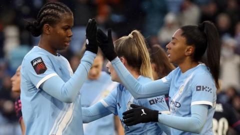 Khadija Shaw and Kerolin celebrate Manchester City's opening goal against Everton with a high five