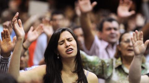 People attend a mass in Evangelica church in Goiania, Goias State, Brazil, on May 19, 2013.