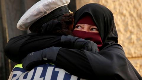 Danish police officer hugs a woman wearing a niqab