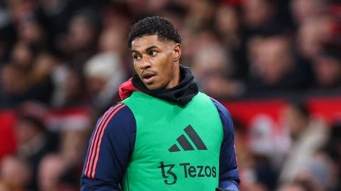 Marcus Rashford in a warm-up bib on the sidelines