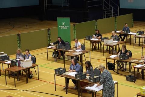 Workers at tables counting votes