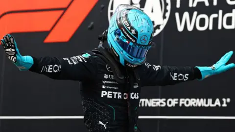 George Russell holds his arms out in celebration after taking Canadian Grand Prix pole