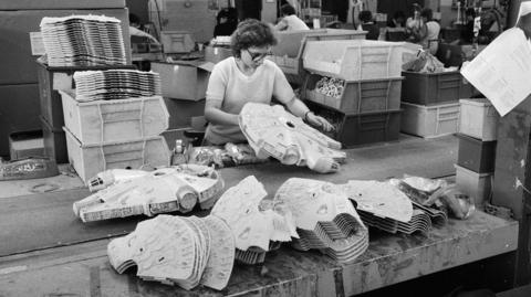 A black and white photo from the 1980s of a woman assembling Millennium Falcons