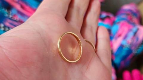 A golden wedding band on a hand
