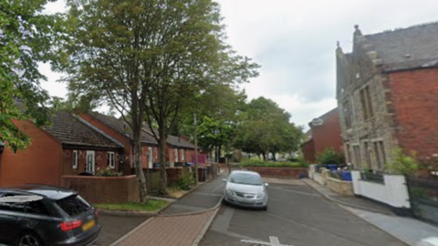 Bank Street in Church - A cul-de-sac with red brick buildings on the left and stone building on the right.
