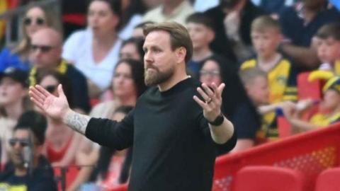 Rob Elliot spreads his arms wide in a gesture of helplessness on the touchline