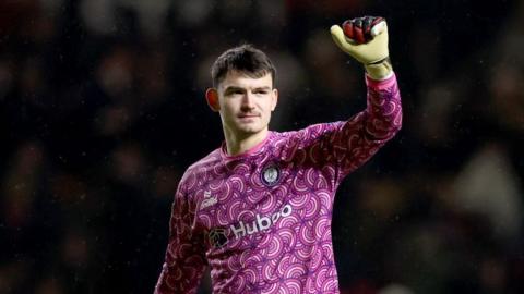 Max O'Leary holds one arm in the air with a fist clenched during a match for Bristol City