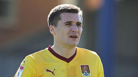 Aaron McGowan playing for Northampton last season, wearing a yellow away kit