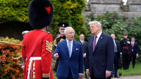 King Charles III (centre) and US President Donald Trump (right) meet military personal after a Beating Retreat military ceremony at Windsor Castle, Berkshire,