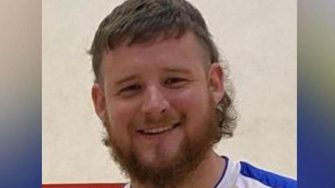 Tom Ellis, smiling and wearing sports kit in a photo issued by police after his death 