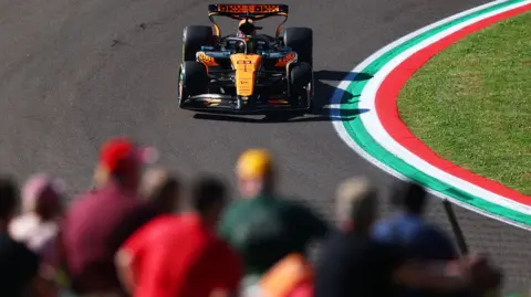 Fans watch on as Oscar Piastri's McLaren passes during second practice for the Emilia-Romagna Grand Prix
