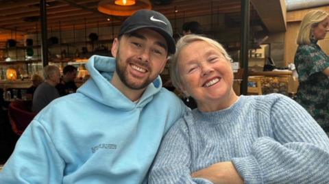 Pauline and Charlie Quirke, sitting side by side, leaning into each other and smiling