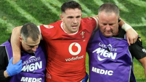 Owen Watkin is helped off against France in the 2025 Six Nations