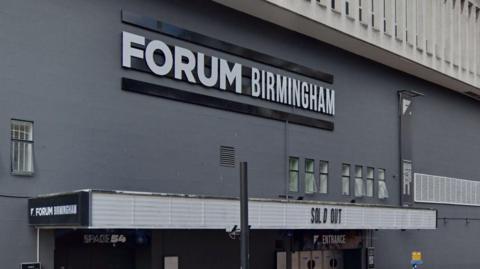 The front of The Forum in Birmingham. It is a grey building. 