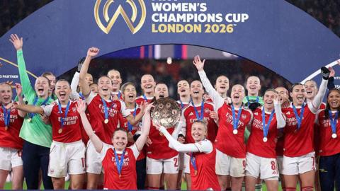 Arsenal players celebrating with the Women's Champions Cup Trophy.