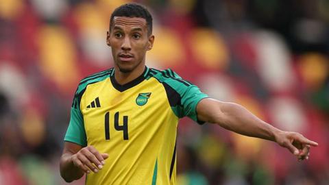 Isaac Hayden points while playing for Jamaica