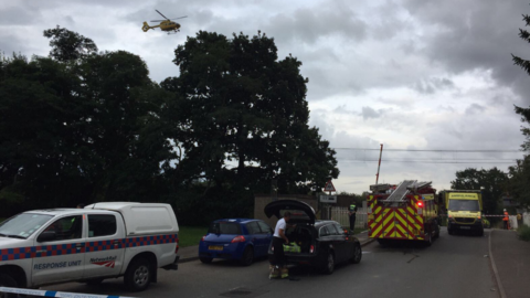 Scene of the incident at Wormley level crossing as air ambulance takes off