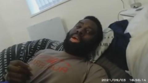 Valdo Calocane being restrained on a bed in his flat by police during a section 135 warrant under the mental health act in September 2021. The image has been taken from police body-worn camera footage dated 3 September 2021.