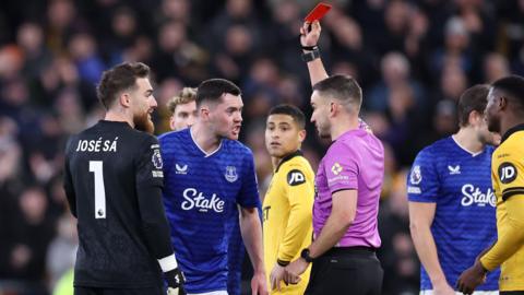 Michael Keane is shown a red card by referee Tom Kirk