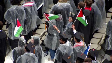 Students holding Palestine flag at graduation